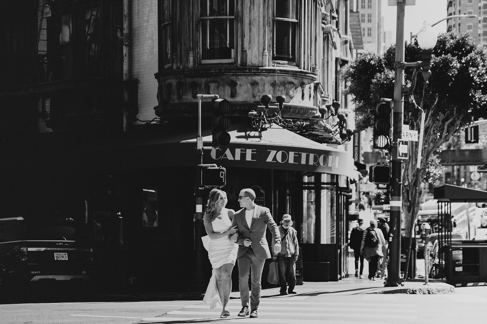 couple crossing the street in front of the Sentinel Building and Cafe Zoetrope