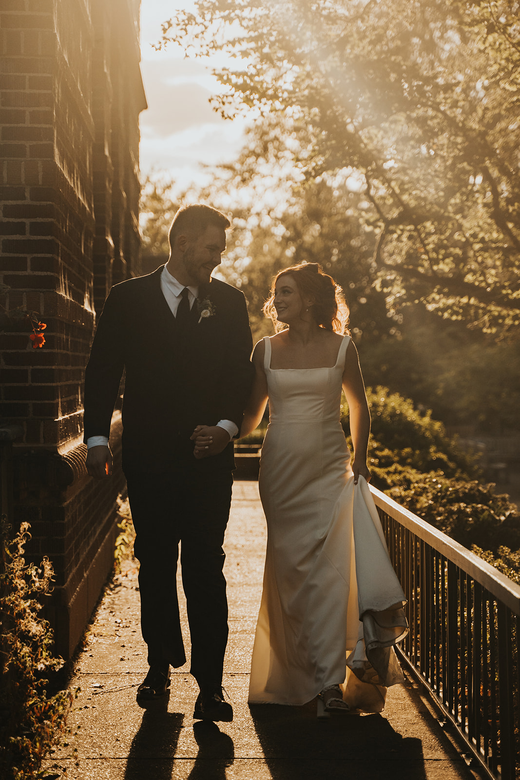 Bride and groom walking next to Gerlinger Hall at University of Oregon, Eugene during golden hour